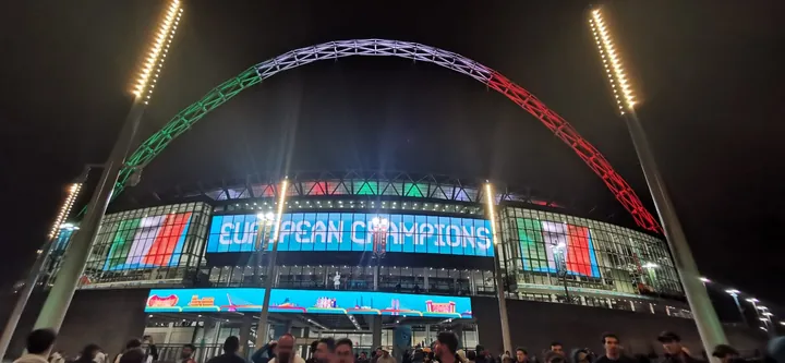 Estádio de Wembley à noite com o arco nas cores de Itália depois da final do Euro 2020